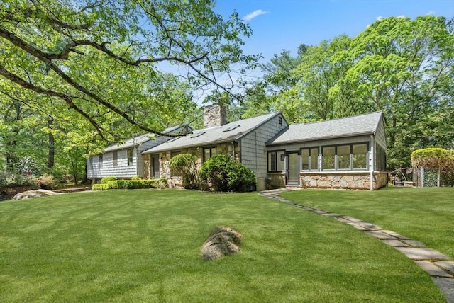 169 Hickory Rd, Weston, MA 02493 - rear view of property featuring stone siding, a lawn, a chimney, and roof with shingles