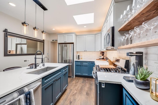 101 Draper St Unit 3, Boston, MA 02122 - kitchen with stainless steel appliances, blue cabinetry, a sink, a skylight, and open shelves