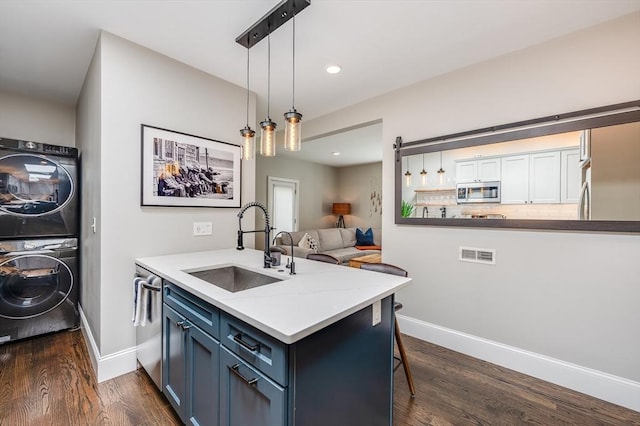 101 Draper St Unit 3, Boston, MA 02122 - kitchen with appliances with stainless steel finishes, a sink, estacked washer and dryer, a peninsula, and dark wood-style flooring