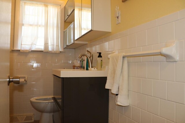 25 Day Rd, Wellfleet, MA 02667 - half bathroom featuring toilet, vanity, visible vents, and tile walls