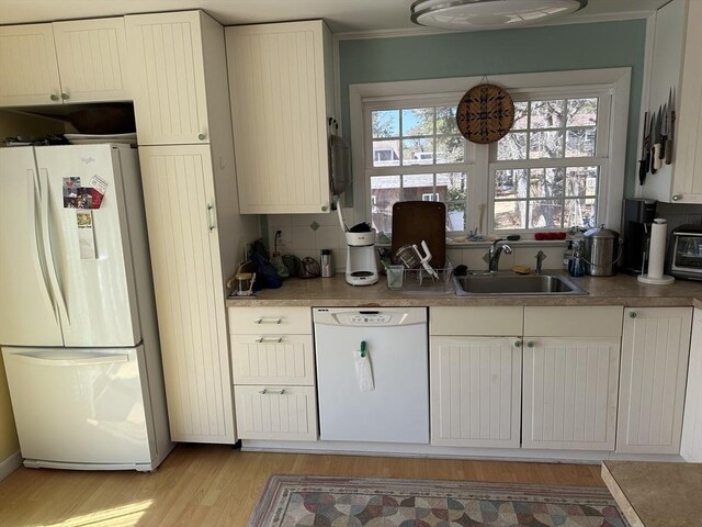 25 Day Rd, Wellfleet, MA 02667 - kitchen with ornamental molding, a sink, white appliances, light wood-style floors, and decorative backsplash