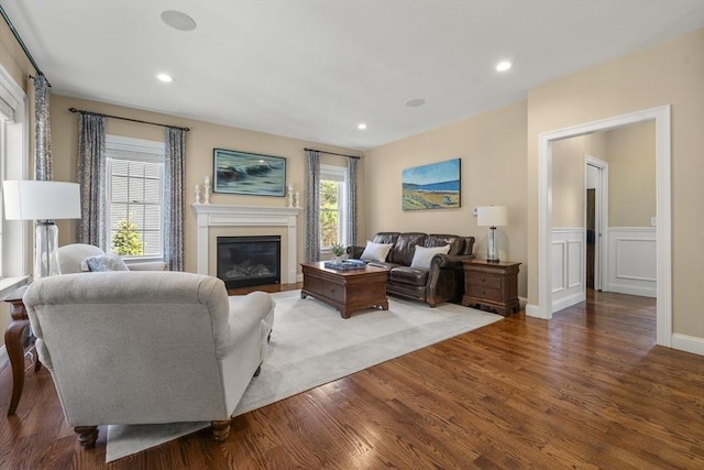 living room featuring recessed lighting, wood finished floors, and a glass covered fireplace