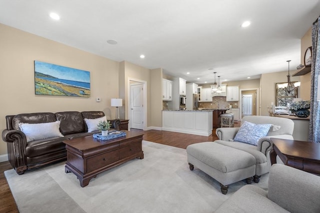 living area featuring an inviting chandelier, recessed lighting, light wood finished floors, and baseboards