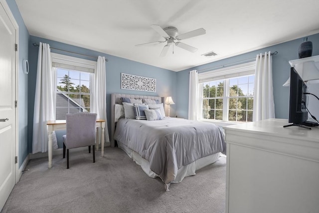 bedroom featuring a ceiling fan, multiple windows, light carpet, and visible vents