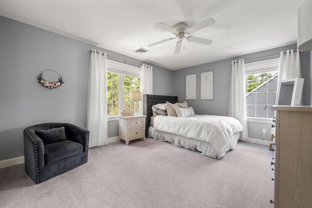 bedroom with baseboards, visible vents, ceiling fan, and light colored carpet