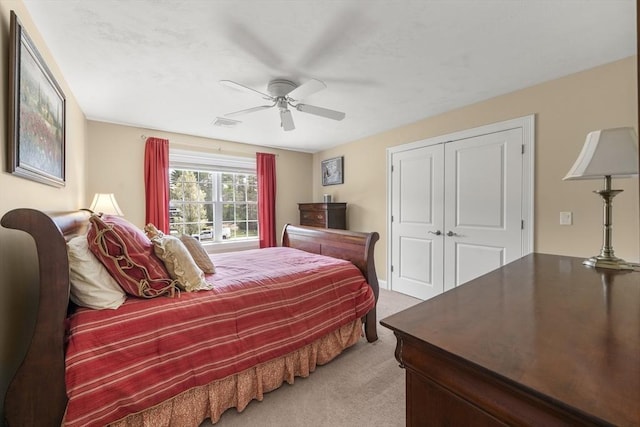 carpeted bedroom with visible vents, a ceiling fan, and a closet