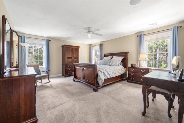 bedroom with light colored carpet, visible vents, ceiling fan, and baseboards