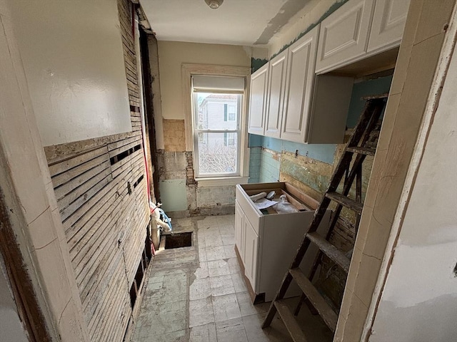 laundry area with wainscoting and tile walls