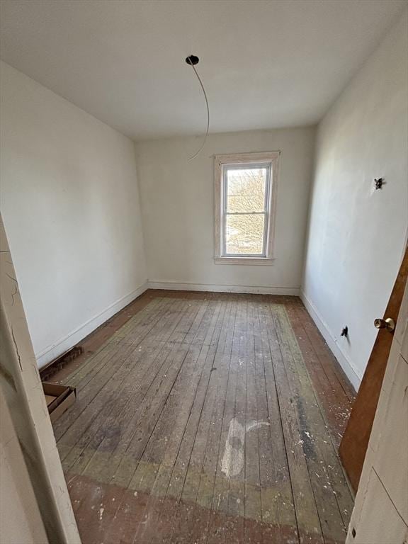 spare room with dark wood-type flooring and baseboards