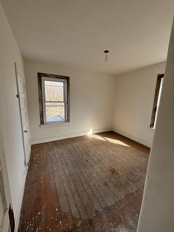 empty room featuring baseboards and dark wood-style flooring