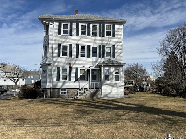 view of front of home featuring a front lawn and a chimney