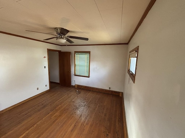 empty room featuring baseboards, ceiling fan, wood finished floors, and crown molding