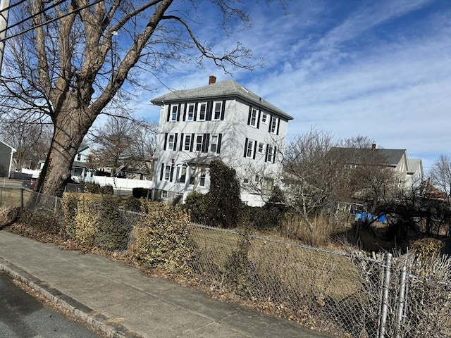 exterior space featuring fence and a chimney