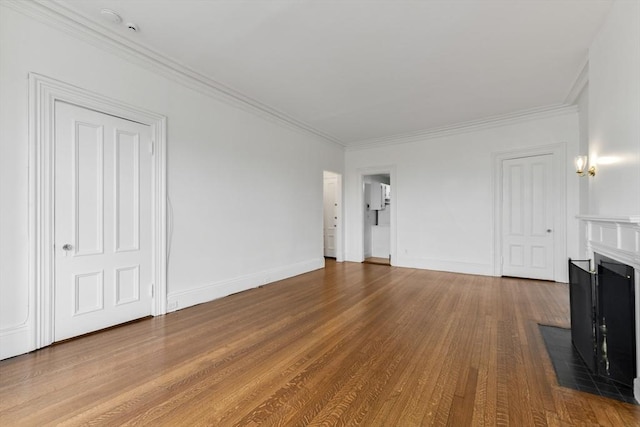 unfurnished living room featuring a fireplace with flush hearth, wood finished floors, ornamental molding, and baseboards