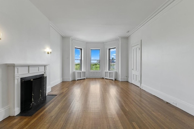 unfurnished living room featuring dark wood-style floors, a fireplace with flush hearth, ornamental molding, and baseboards