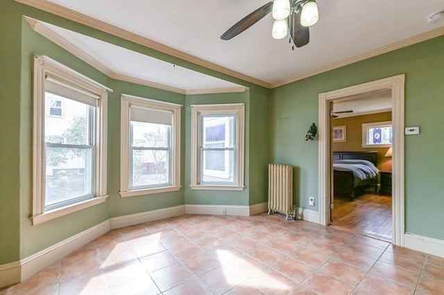 unfurnished room featuring radiator, crown molding, a ceiling fan, and light tile patterned floors