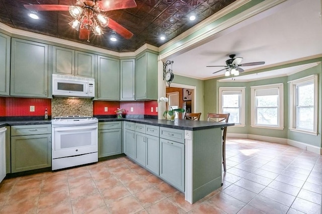kitchen with green cabinetry, a ceiling fan, ornamental molding, and white appliances