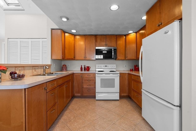 kitchen with white appliances, light tile patterned flooring, a sink, light countertops, and brown cabinets