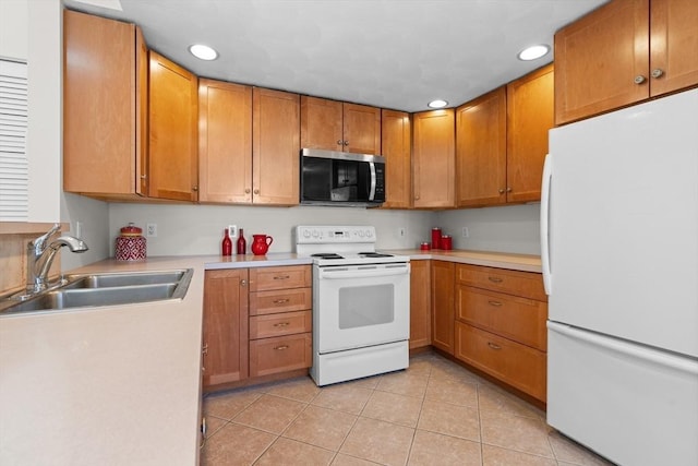 kitchen featuring a sink, white appliances, brown cabinetry, light countertops, and light tile patterned floors