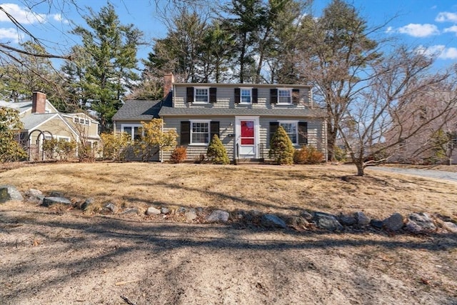 view of front facade with a front lawn and a chimney