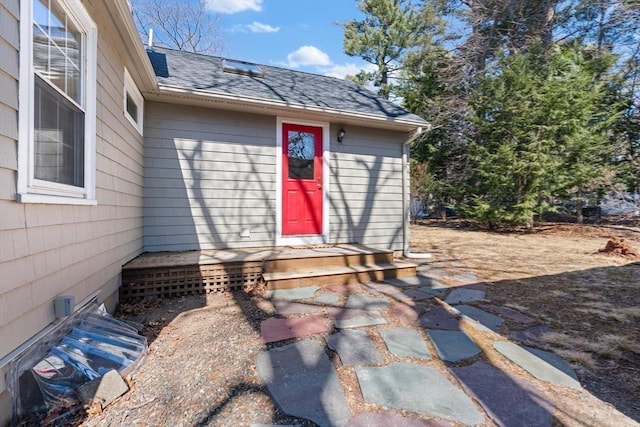 property entrance featuring roof with shingles