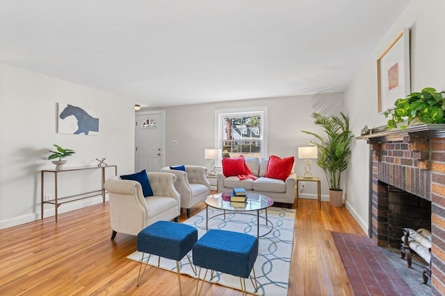 living room with baseboards, a brick fireplace, and wood finished floors