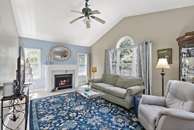 living area with baseboards, a ceiling fan, lofted ceiling, and a premium fireplace