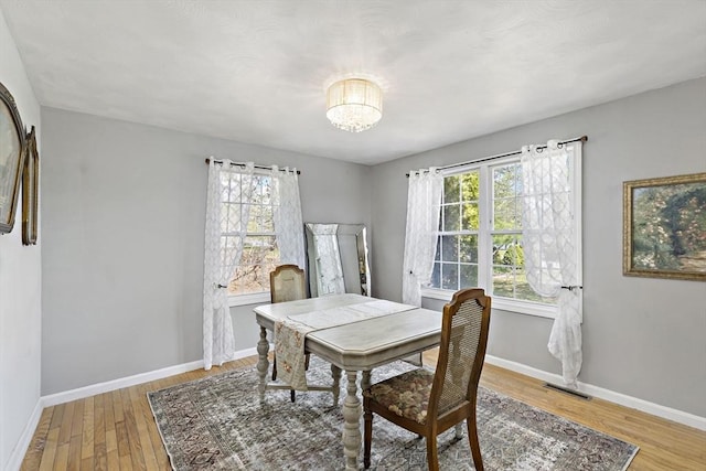 dining space with visible vents, baseboards, a healthy amount of sunlight, and light wood-type flooring