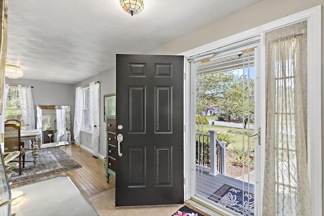 entrance foyer featuring baseboards, plenty of natural light, and light tile patterned floors