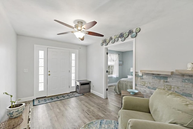 entryway featuring baseboards, a ceiling fan, and wood finished floors