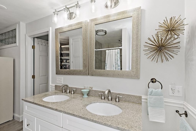 bathroom featuring double vanity, a sink, and a shower with curtain