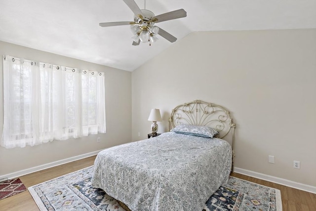 bedroom with baseboards, a ceiling fan, lofted ceiling, and wood finished floors