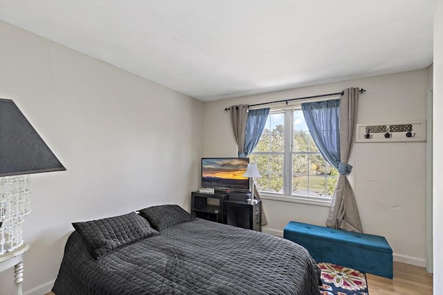 bedroom with baseboards and wood finished floors