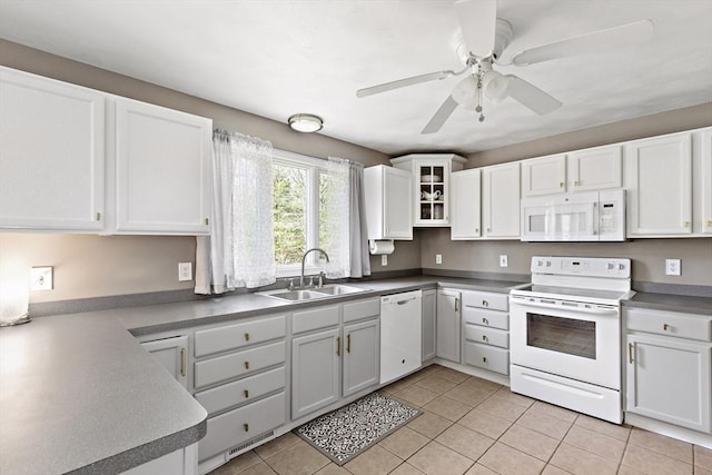 kitchen featuring a sink, light tile patterned flooring, white appliances, and white cabinetry