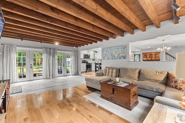 101 Titicut Rd, Raynham, MA 02767 - living area featuring french doors, wood finished floors, beamed ceiling, and a chandelier