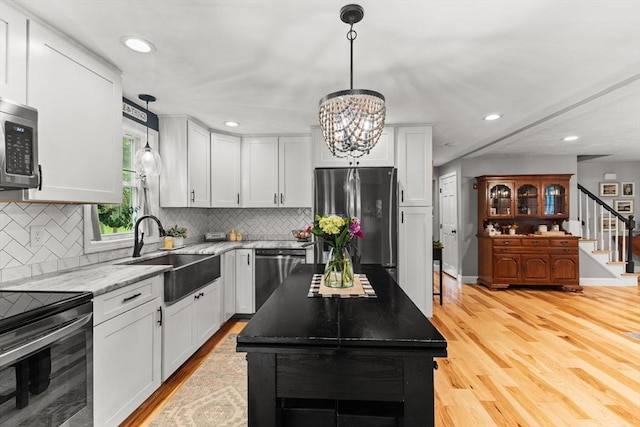 101 Titicut Rd, Raynham, MA 02767 - kitchen with appliances with stainless steel finishes, a sink, light wood-style floors, recessed lighting, and backsplash