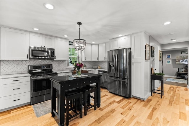 101 Titicut Rd, Raynham, MA 02767 - kitchen featuring appliances with stainless steel finishes, backsplash, light wood-style floors, a chandelier, and recessed lighting