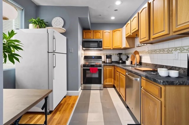 5 Sutton St Unit 3B, Boston, MA 02126 - kitchen featuring appliances with stainless steel finishes, a sink, decorative backsplash, dark countertops, and recessed lighting