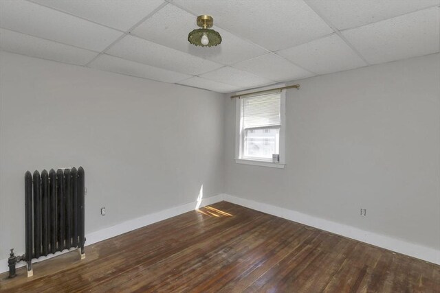 82 Grove St, North Brookfield, MA 01535 - empty room with radiator heating unit, a paneled ceiling, wood finished floors, and baseboards