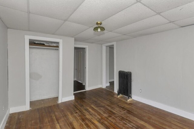 82 Grove St, North Brookfield, MA 01535 - unfurnished bedroom featuring radiator heating unit, a drop ceiling, wood finished floors, baseboards, and a closet