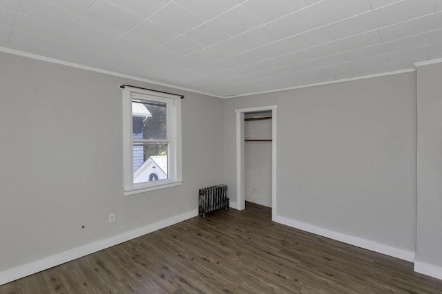 82 Grove St, North Brookfield, MA 01535 - unfurnished bedroom featuring radiator heating unit, crown molding, dark wood-type flooring, baseboards, and a closet
