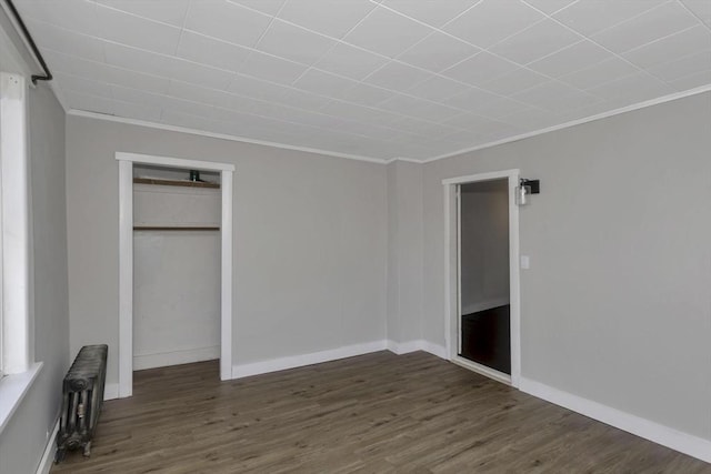 82 Grove St, North Brookfield, MA 01535 - unfurnished bedroom featuring radiator heating unit, crown molding, wood finished floors, a closet, and baseboards