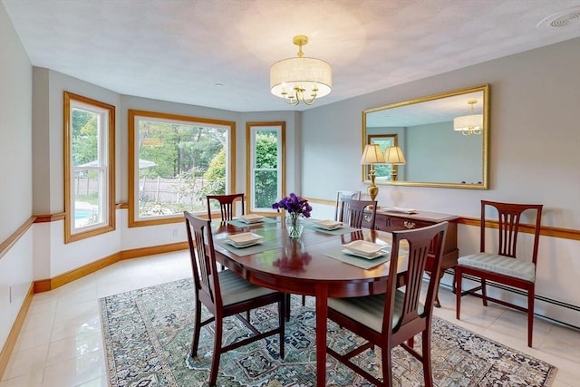 dining area with a chandelier, baseboards, light tile patterned floors, and a baseboard heating unit