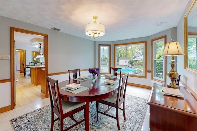 dining room featuring light tile patterned floors, baseboards, and a chandelier