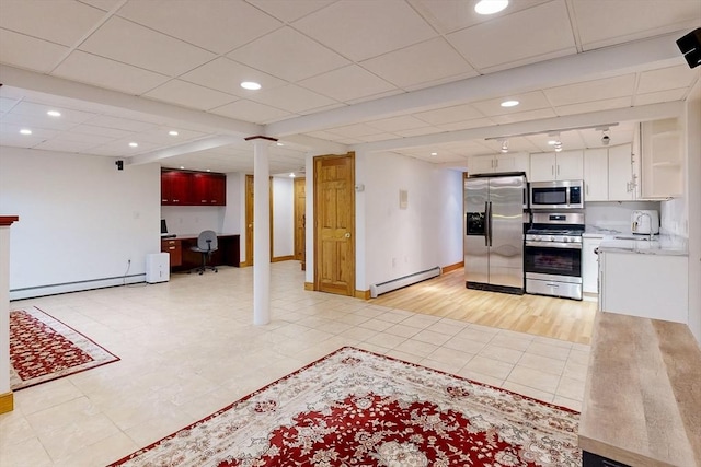 kitchen featuring stainless steel appliances, a baseboard heating unit, baseboard heating, light countertops, and a desk