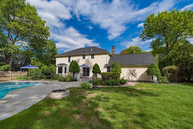 back of house with an outdoor fire pit, a wooden deck, a chimney, and a patio