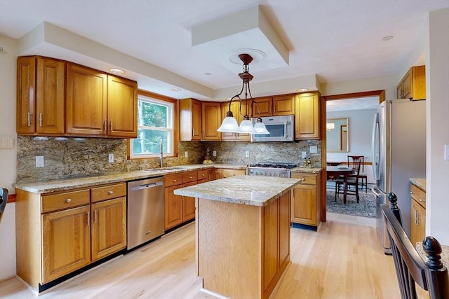 kitchen featuring appliances with stainless steel finishes, light wood-type flooring, and brown cabinets