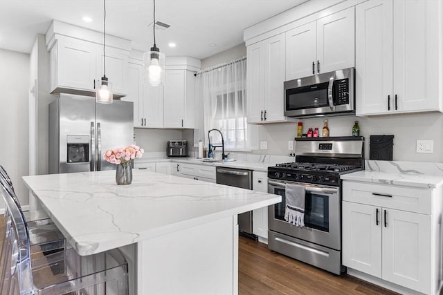 105 Depot St Unit A, Milford, MA 01757 - kitchen with stainless steel appliances, a sink, white cabinetry, a breakfast bar, and light stone countertops