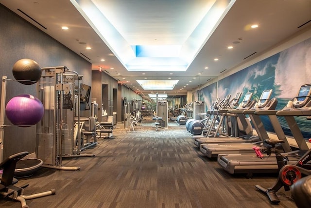 exercise room with carpet and a tray ceiling