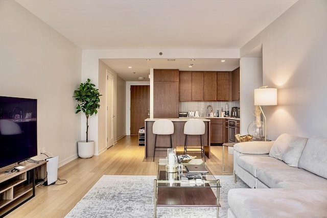 living room featuring sink and light hardwood / wood-style floors